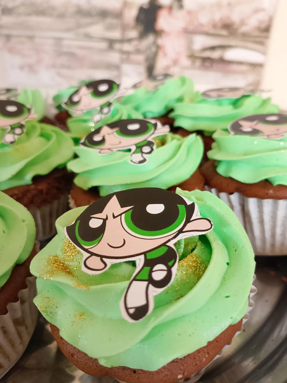 Cupcakes decorados com cobertura verde e topo personalizado com personagem animado